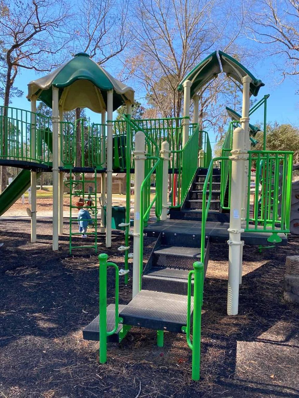 Bright green and beige playground equipment at a park, ideal for children's outdoor fun and recreation.