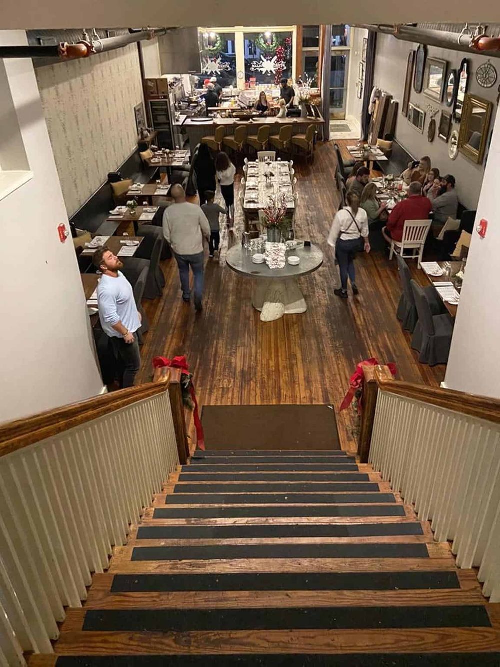 Cozy restaurant interior with holiday decorations and warm wooden floors, perfect for festive dining experiences.