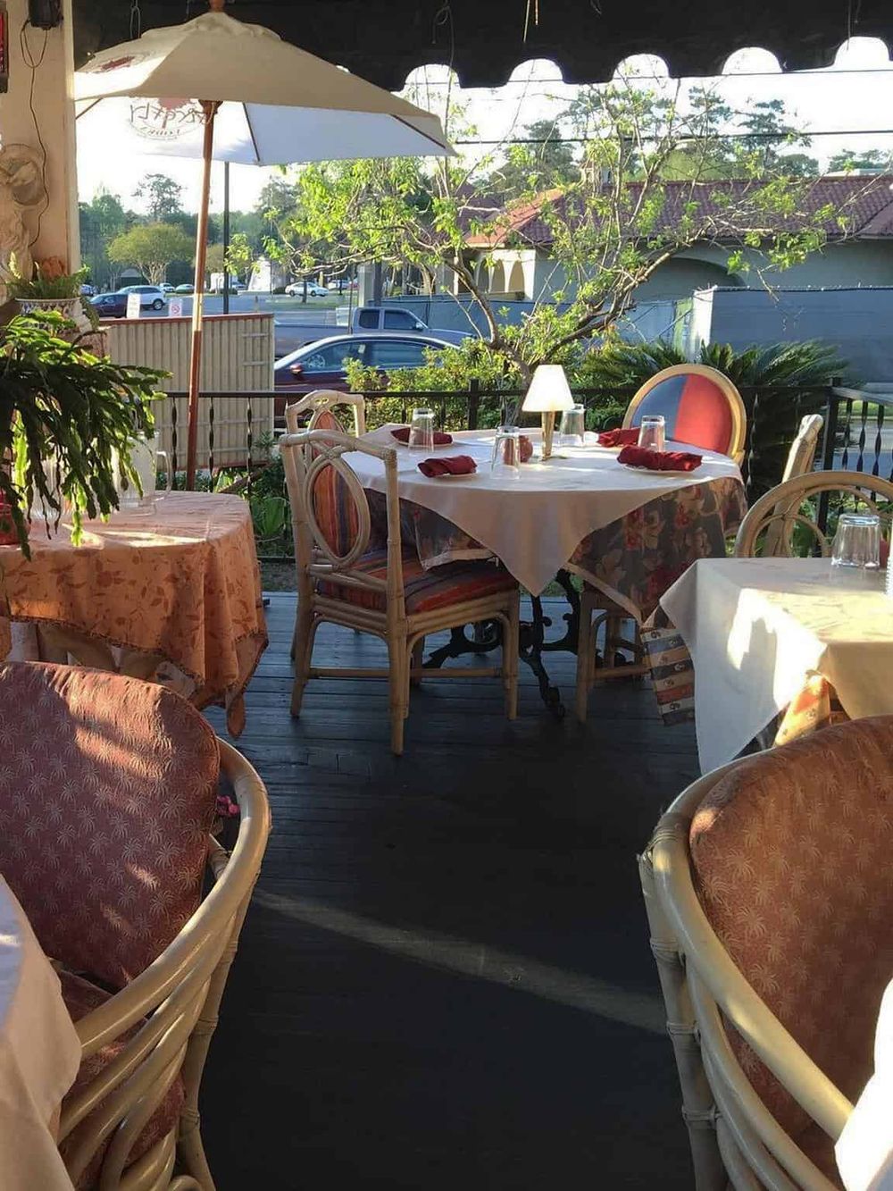 Cozy outdoor restaurant terrace with elegant tables, chairs, and umbrellas, perfect for dining and relaxing.