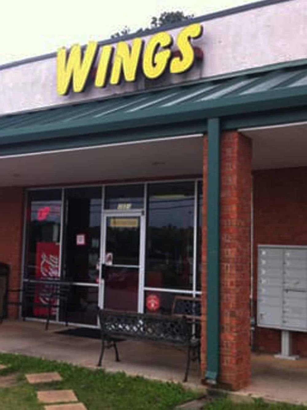 Delicious wings restaurant exterior with bold signage, outdoor seating, and a welcoming atmosphere. Perfect for wing lovers and takeout.