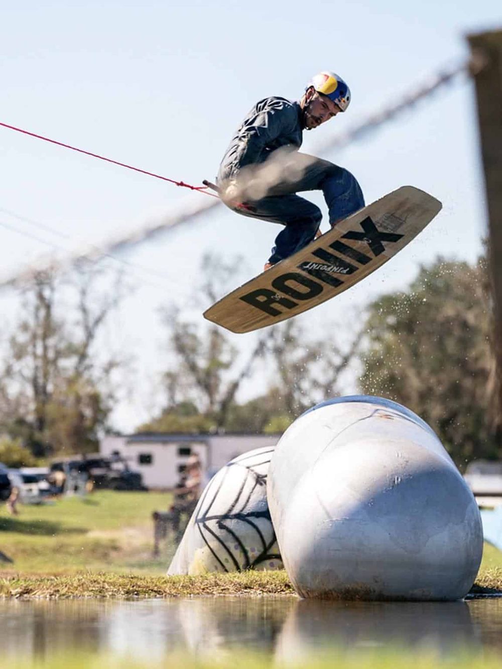 1. Man wakeboarding and wake surfacing on a clear day for adventure and water sports.