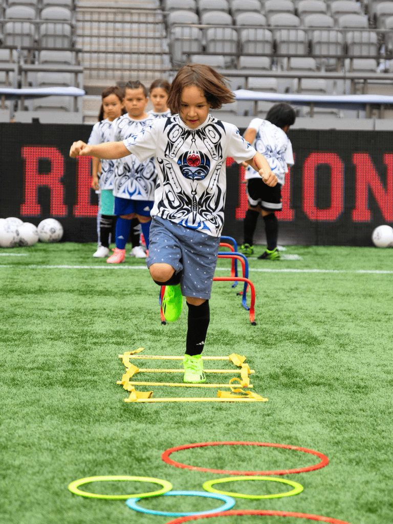 Agility training for kids at soccer field, children practicing footwork and coordination.