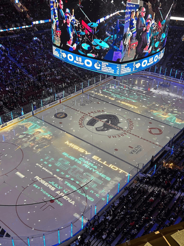 Music performance at Rogers Arena with projected advertising on the ice rink.