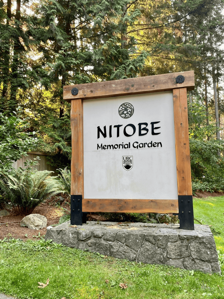 Serene memorial garden entrance at Nitobe Memorial Garden, lush greenery and trees surrounding the peaceful site.