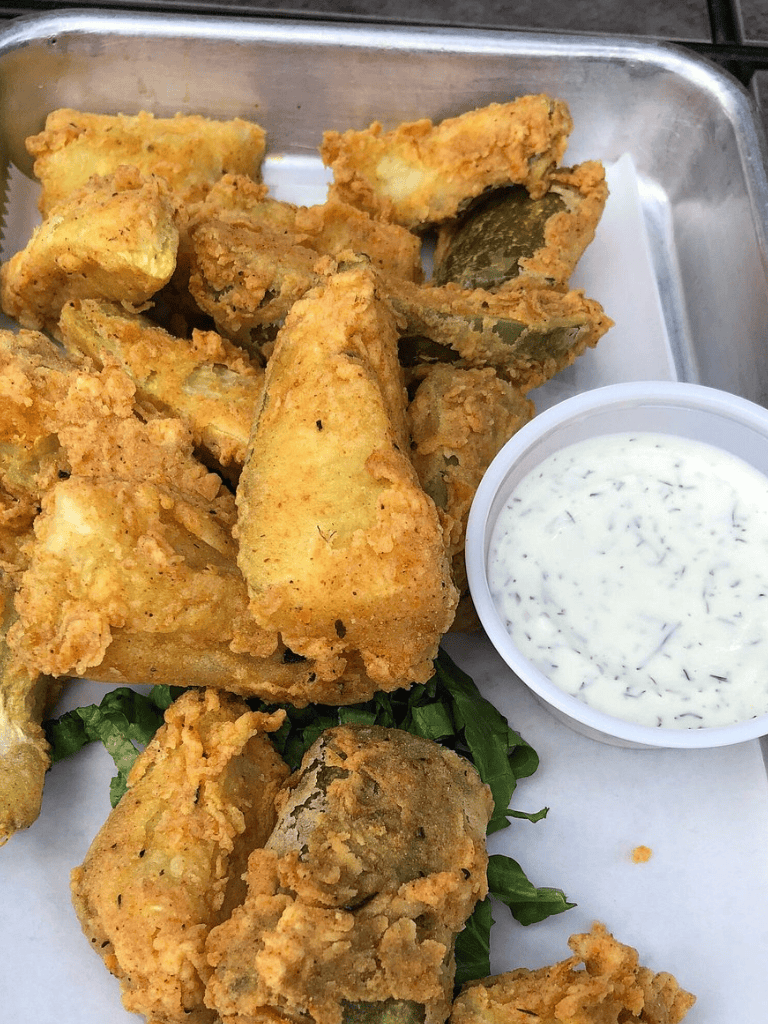 Crispy fried fish andouille with tartar sauce, fresh greens, and crispy fried mushrooms. Perfect seafood platter for lunch or dinner.