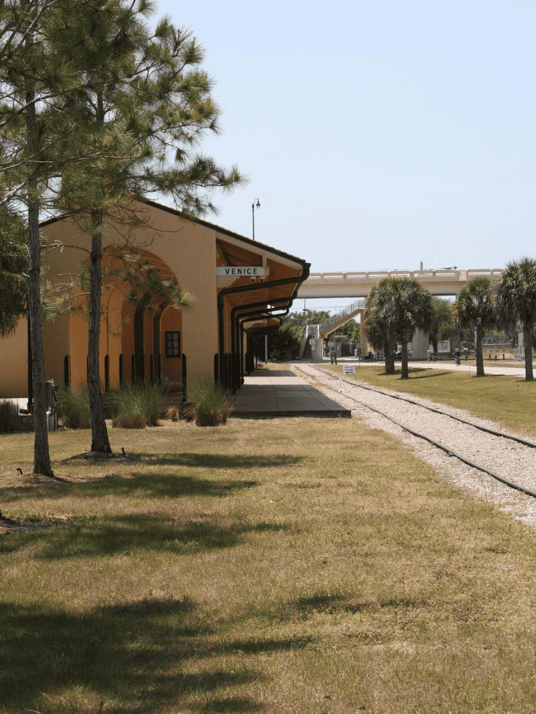 Venice train station with platform and surrounding greenery, Florida train transportation hub.
