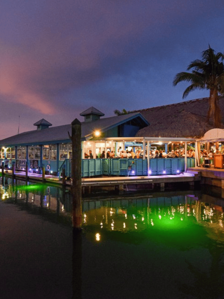 Outdoor waterfront dining at QuestForDirections restaurant with vibrant evening ambiance.