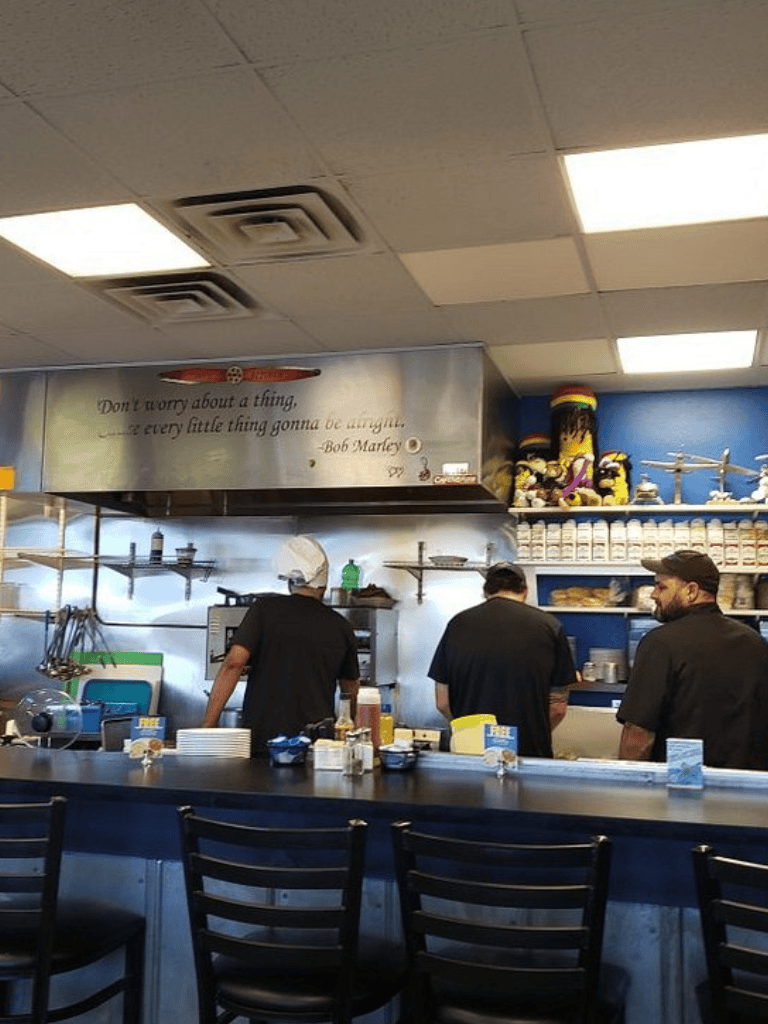 Pizza restaurant kitchen interior with staff preparing food.
