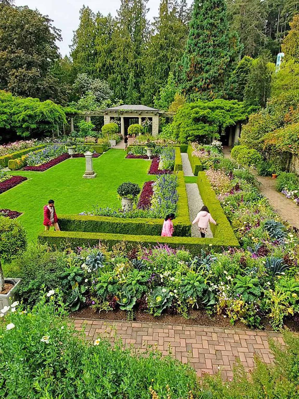 Serene garden with colorful flowers, lush greenery, and a classical gazebo for relaxation.