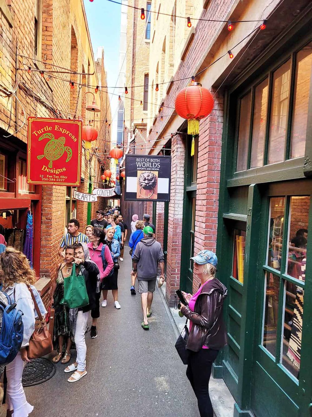 Colorful alleyway with lanterns and busy crowd, perfect for exploring local shops and dining.