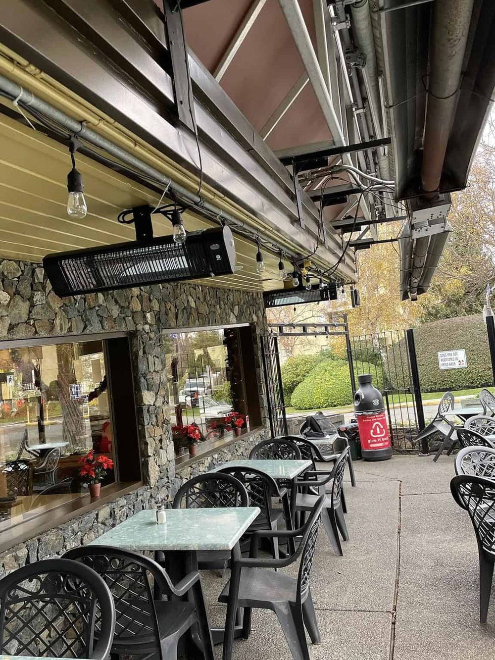 Outdoor dining area of a restaurant with tables, chairs, and festive decor.