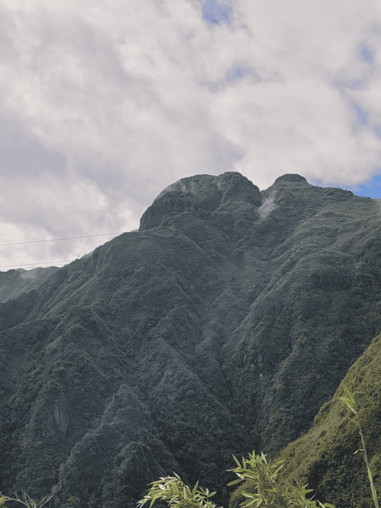 Stunning mountain landscape with lush green slopes and cloudy sky, perfect for adventure and nature photography.