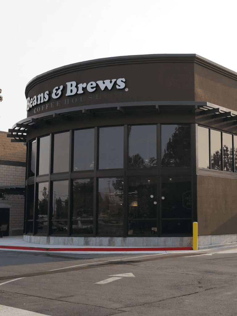 Modern coffee shop exterior at Jean & Brews Coffee House, an inviting local café in a commercial area.