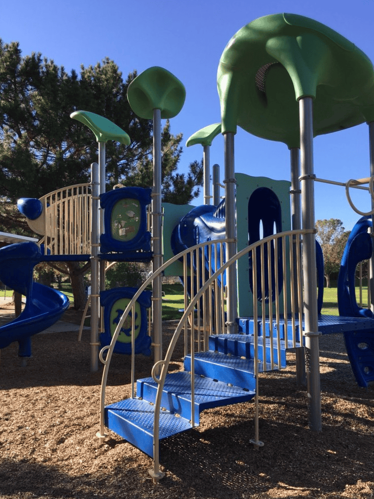 Colorful playground structure for kids, outdoor play area with slides and climbing features.