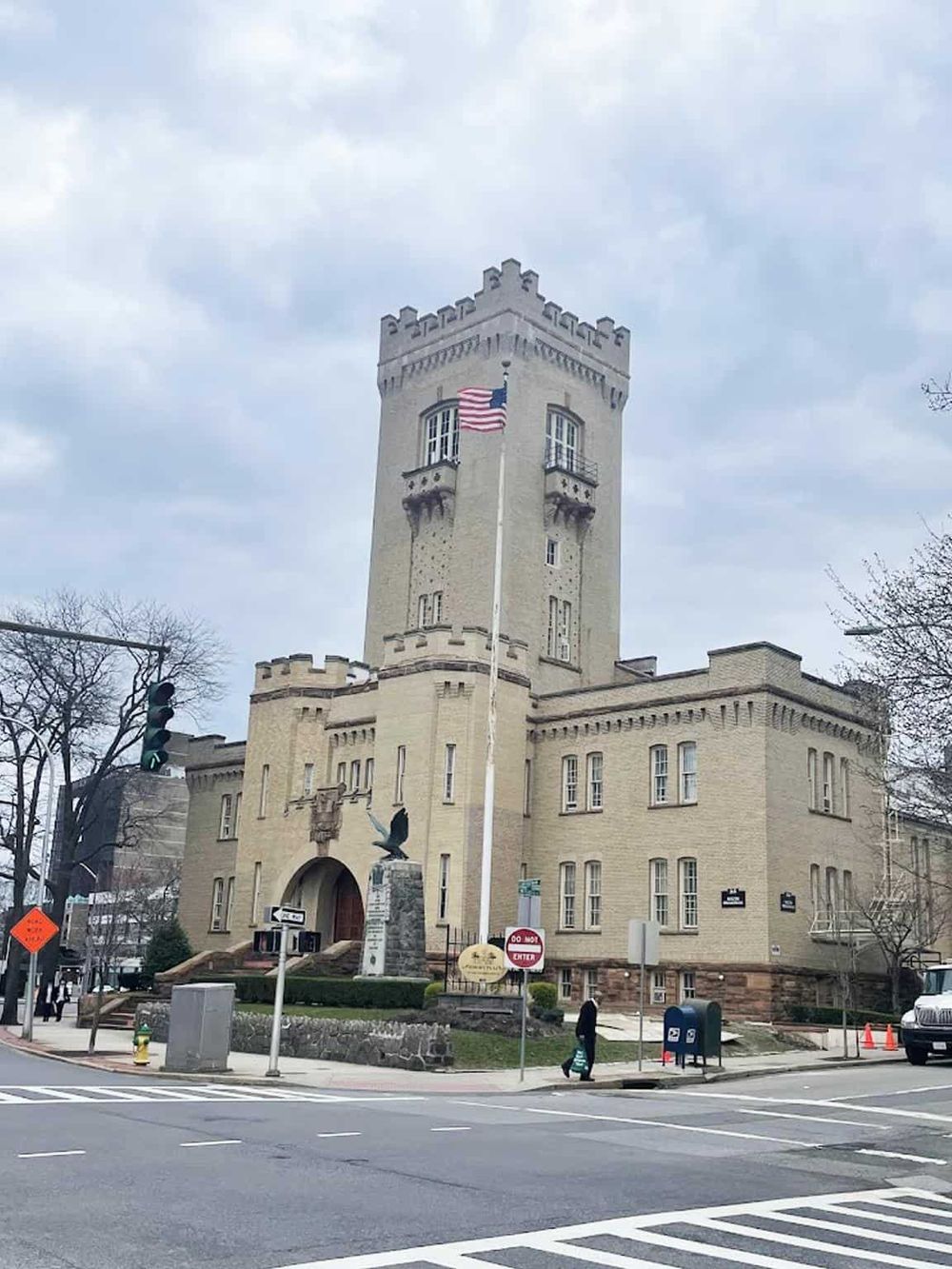Historic castle-style tower in downtown with American flag, perfect for travel directions and landmarks.