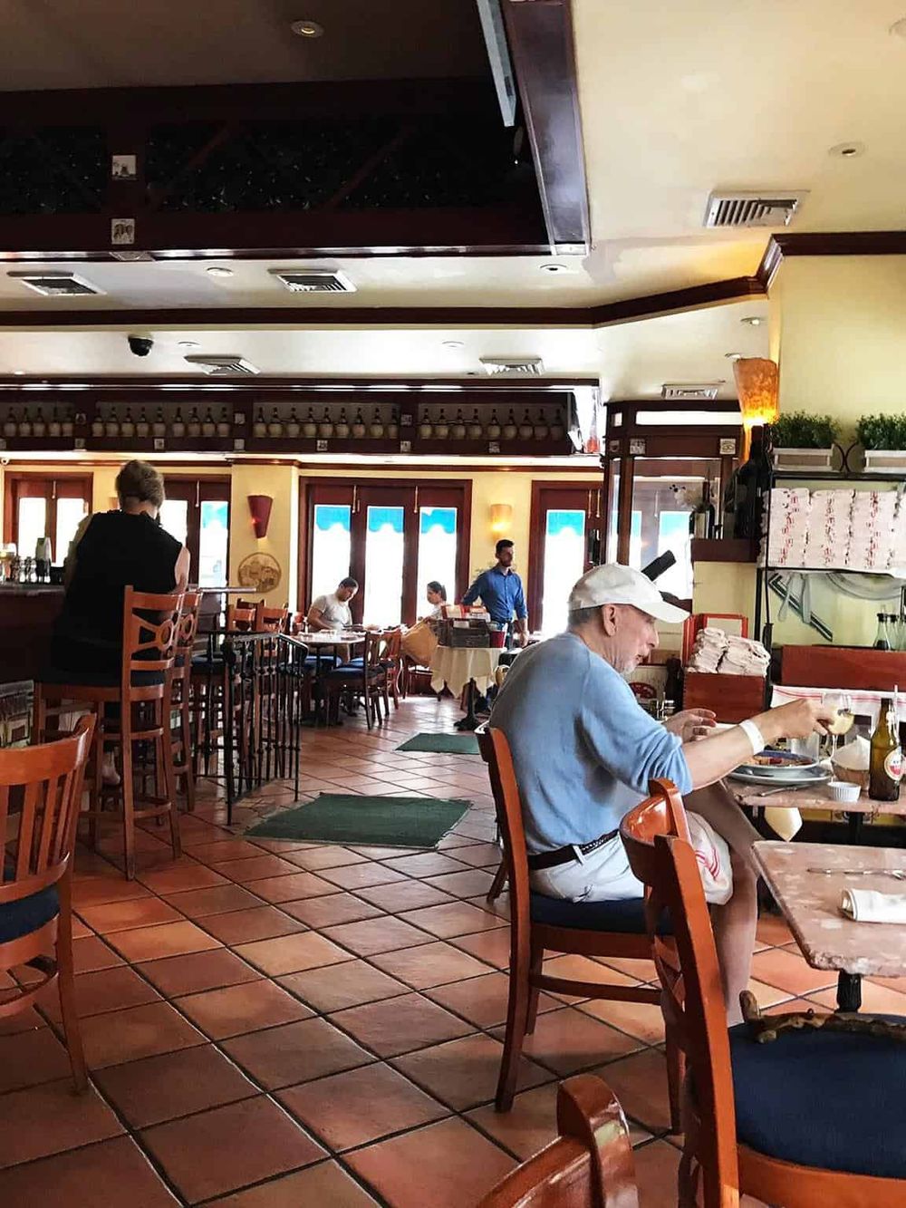 Bright restaurant dining area with patrons enjoying meals and scenic windows in the background.