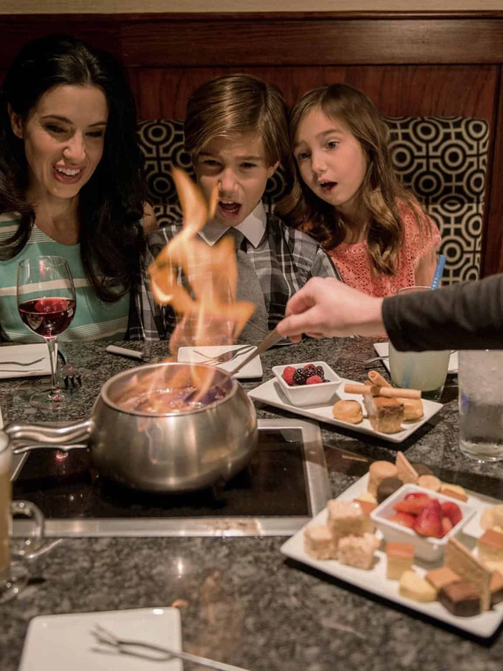 Exciting family dinner with flaming dessert and delicious sweets at a restaurant.