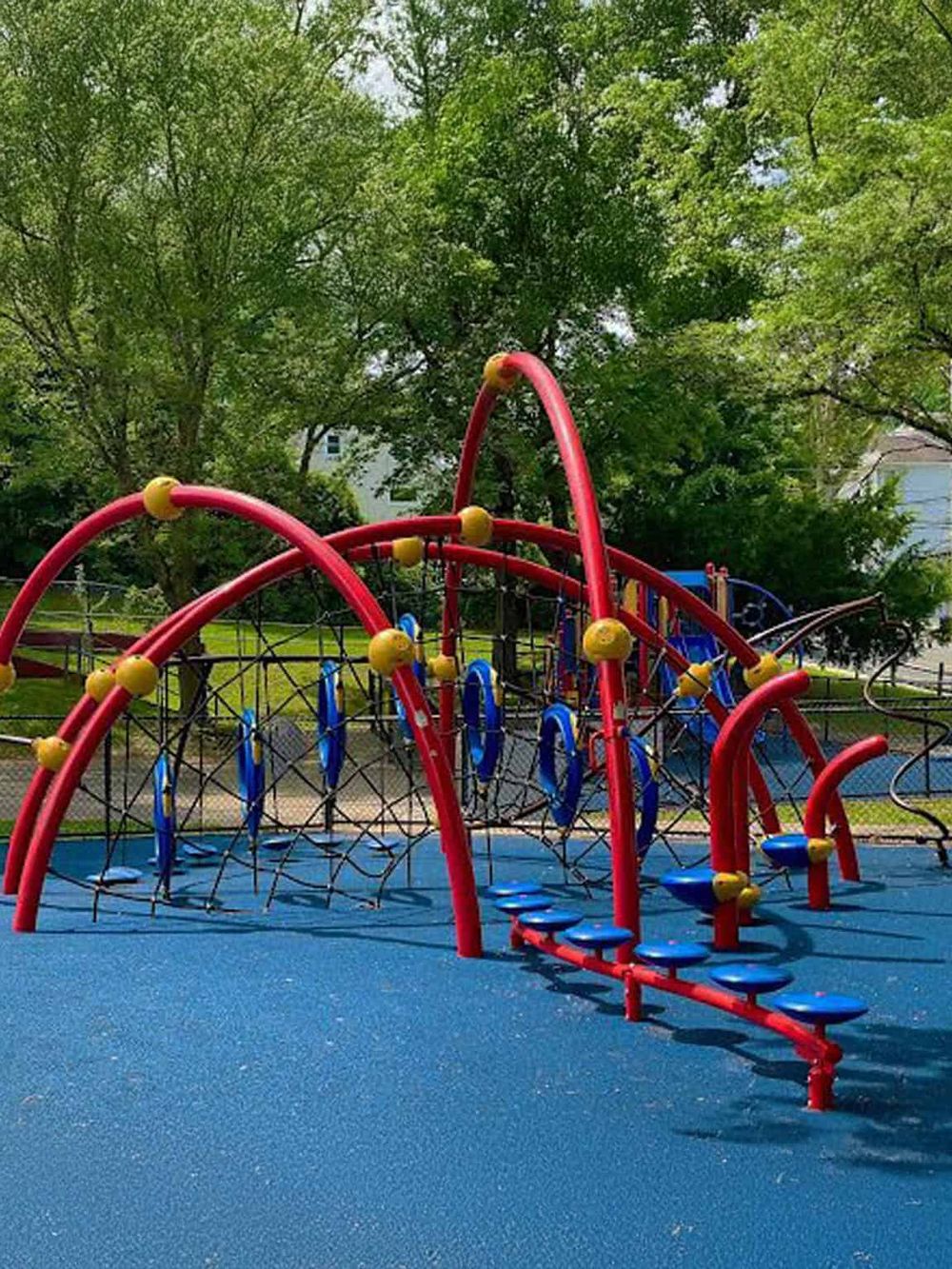 Vibrant children's playground with climbing structures and slides in a park setting.