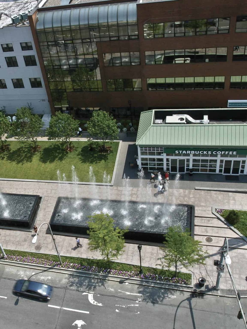 Modern urban area with Starbucks coffee shop and water fountains in downtown.