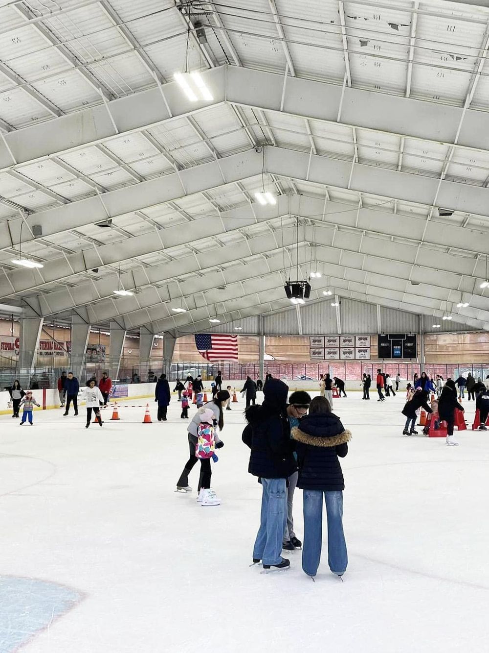 Indoor ice skating rink for recreational skating and family fun, with visitors enjoying the ice in a large, well-lit facility.