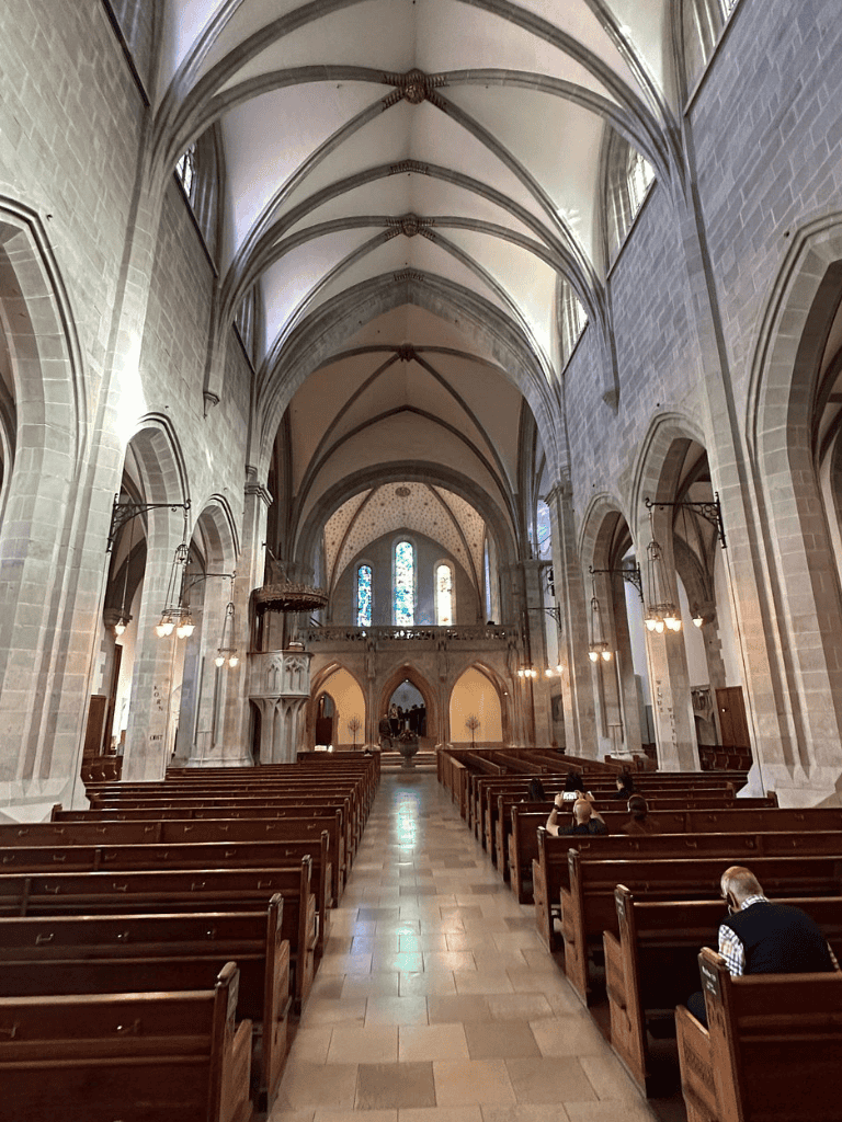 Grand Gothic cathedral interior with high vaulted ceilings and ornate arches.