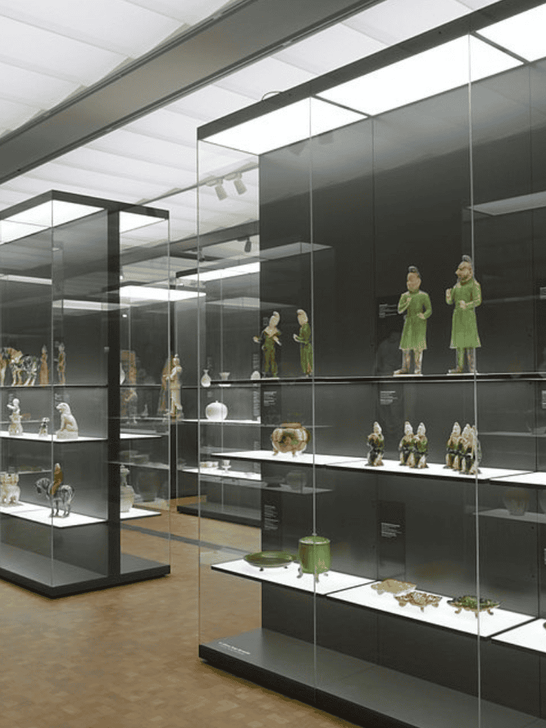 Antique Asian ceramic and porcelain art exhibits in glass display cases at museum.