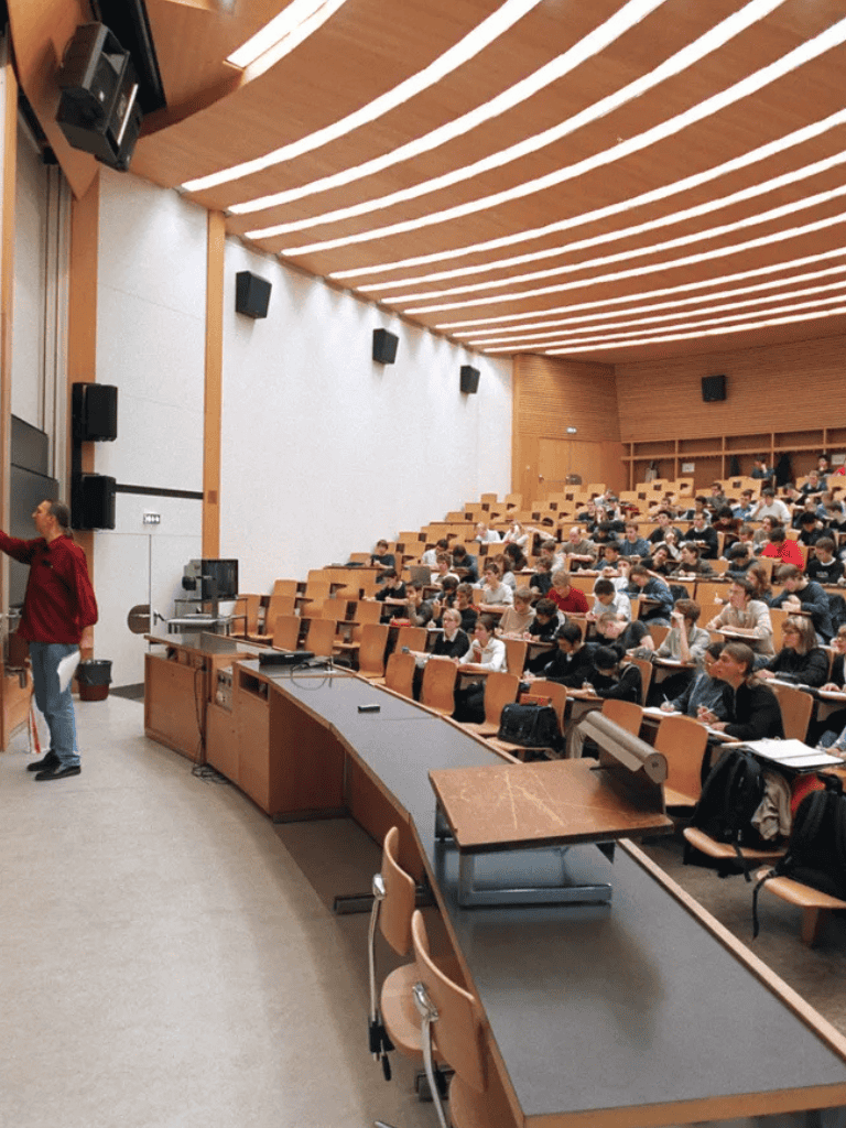 Classroom lecture hall with students taking notes during a university class session.