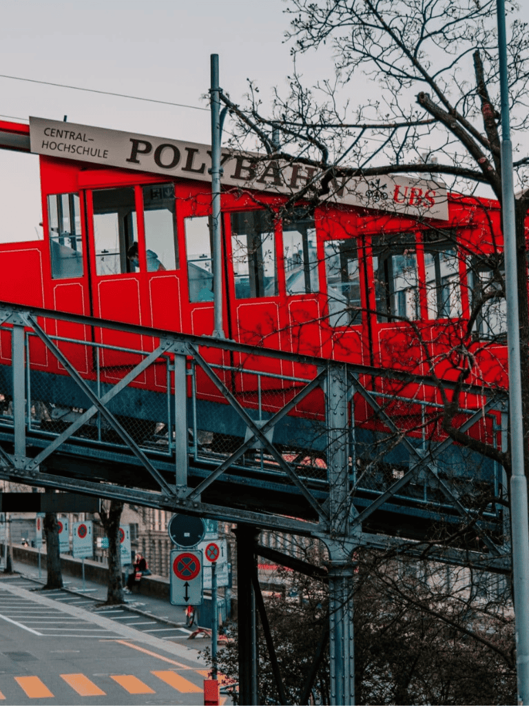 Red pedestrian bridge with central university sign and trees, Berlin cityscape, urban transit infrastructure, Quest for Directions.