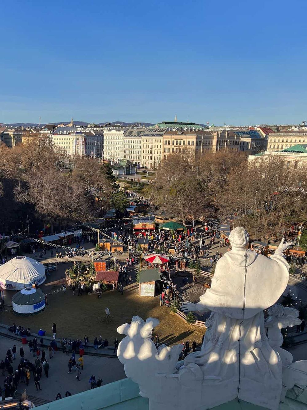 Colorful outdoor market scene in Vienna with historic architecture and festive decorations, offering guided tours and travel advice.