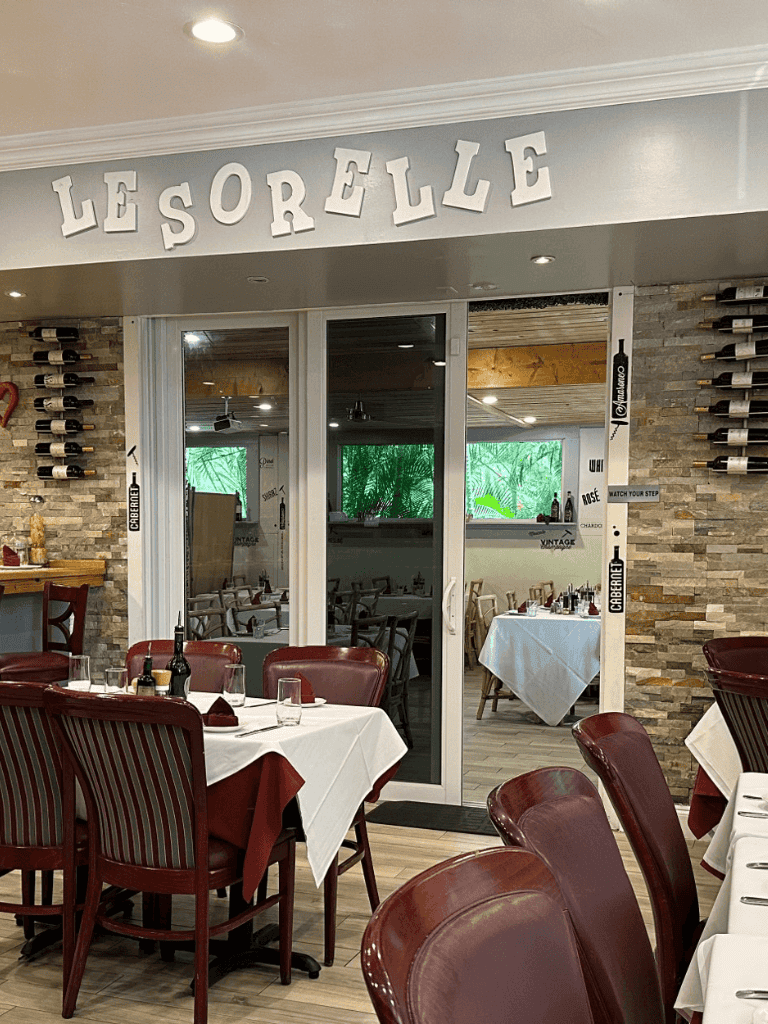 Elegant restaurant interior with white tablecloths and wine bottles, Lesorelle signage, ideal for fine dining.