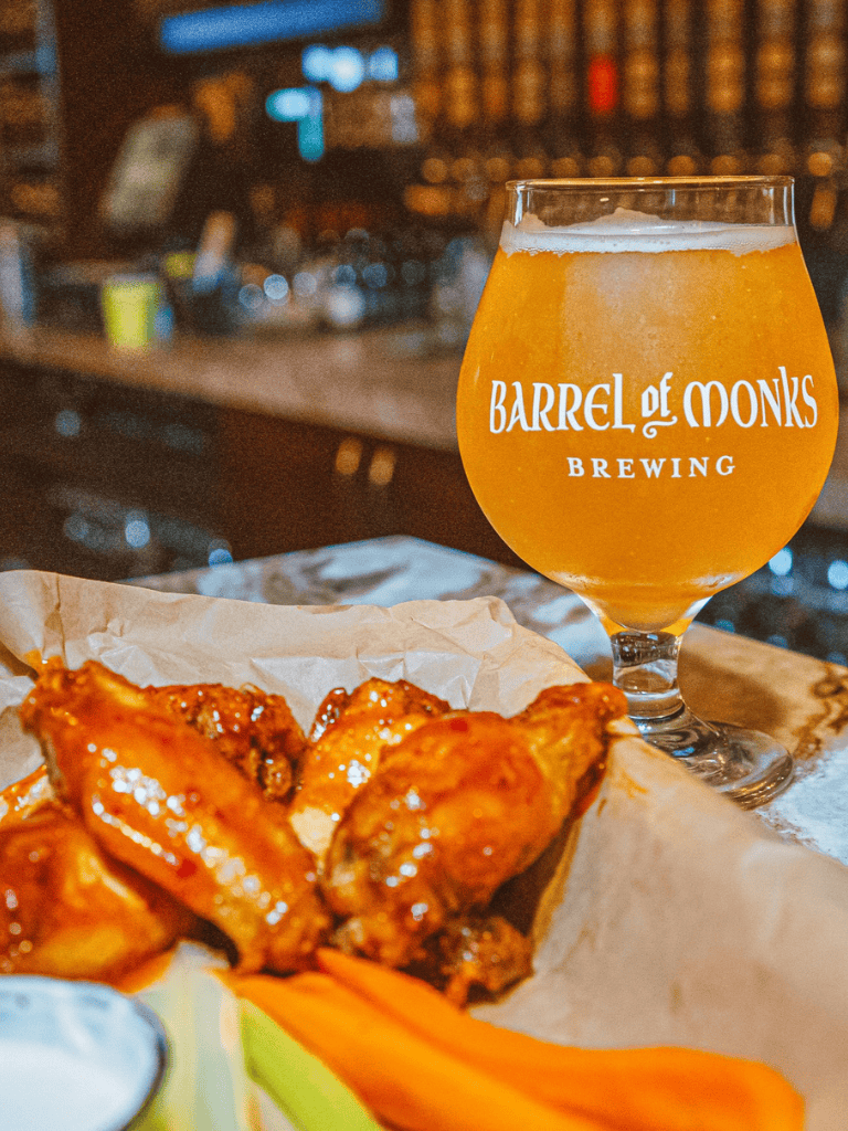 Craft beer and crispy chicken wings at Barrel of Monks Brewing, perfect for food lovers.