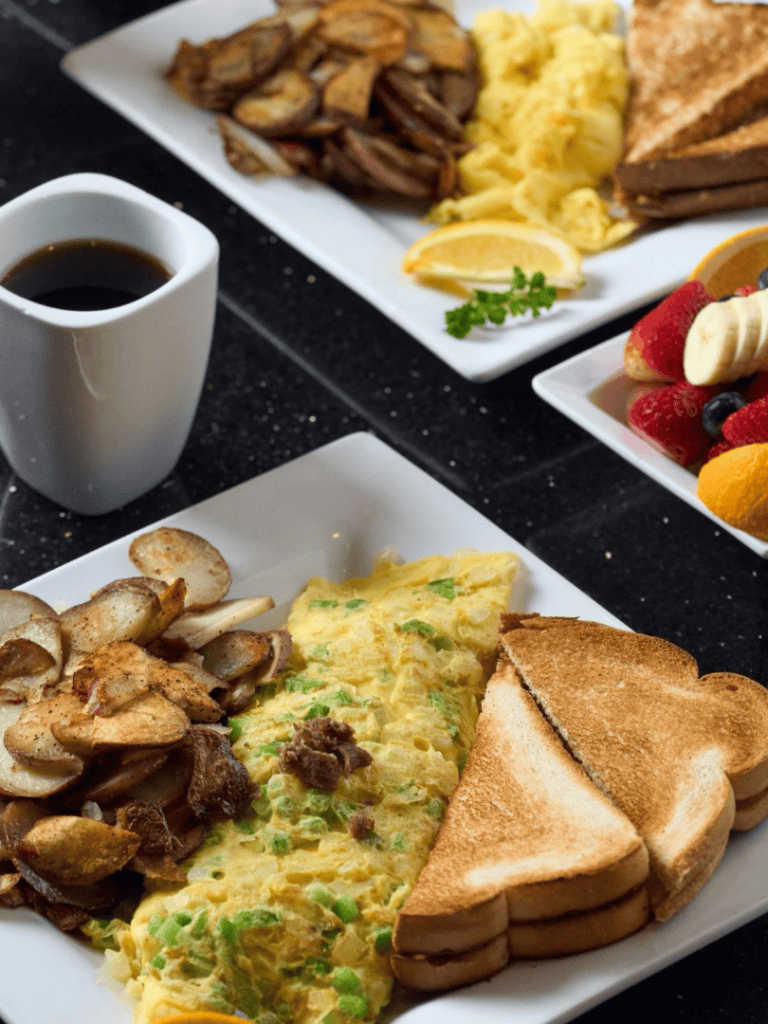 Comfort food breakfast with scrambled eggs, grilled mushrooms, toasted bread, and coffee.