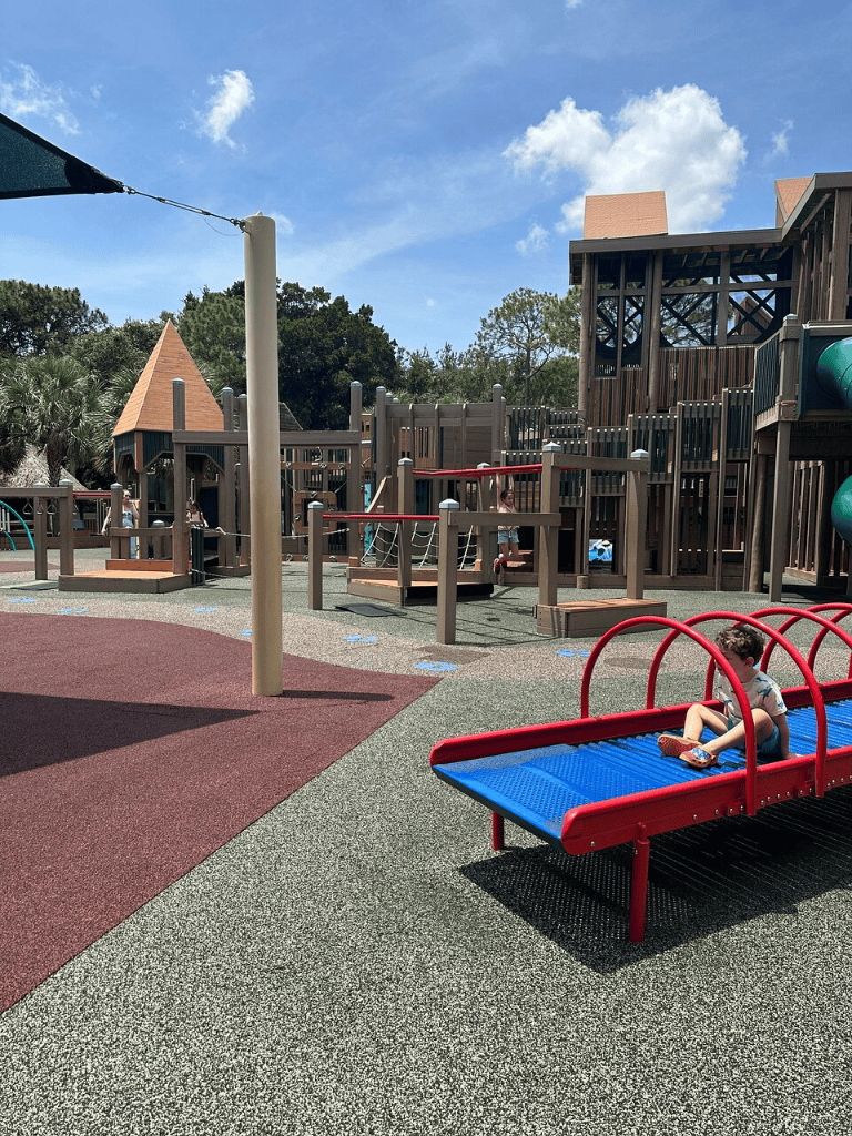 Colorful playground equipment and kids playing at Quest For Directions outdoor play area.