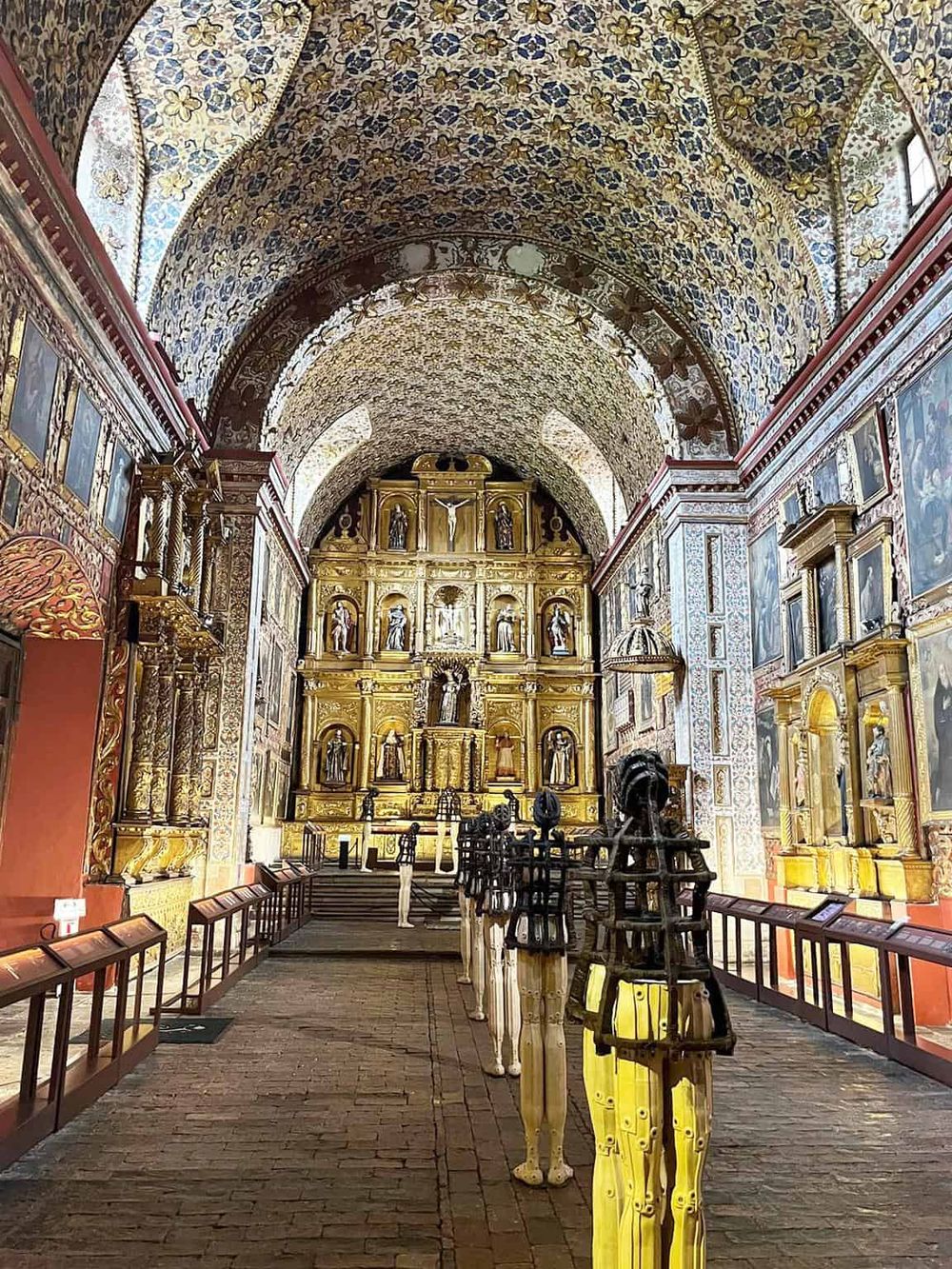 Intricate historic church interior with ornate gold altar and religious artwork, showcasing cultural heritage.
