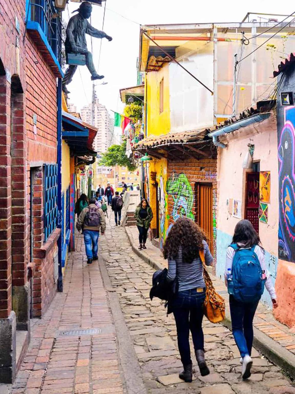 Colorful street art in a vibrant urban alleyway with pedestrians exploring, ideal for travel and cultural exploration keywords.