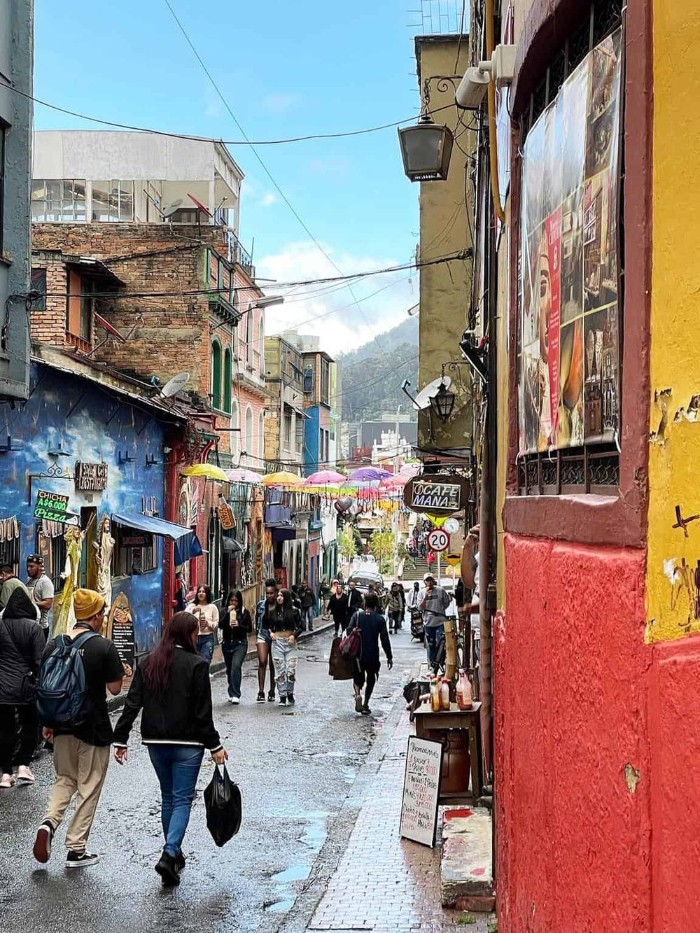 Colorful street in San Cristobal de las Casas with vibrant shops and pedestrians.