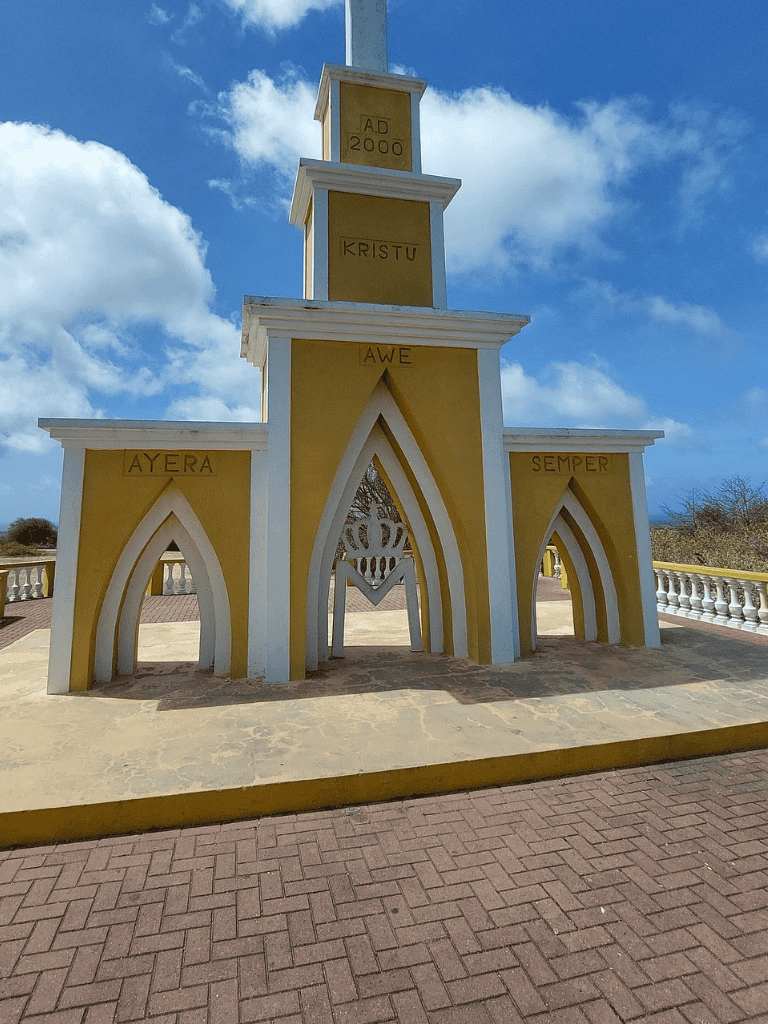 Colorful monument of spiritual architecture with Latin inscriptions and a clear sky background.