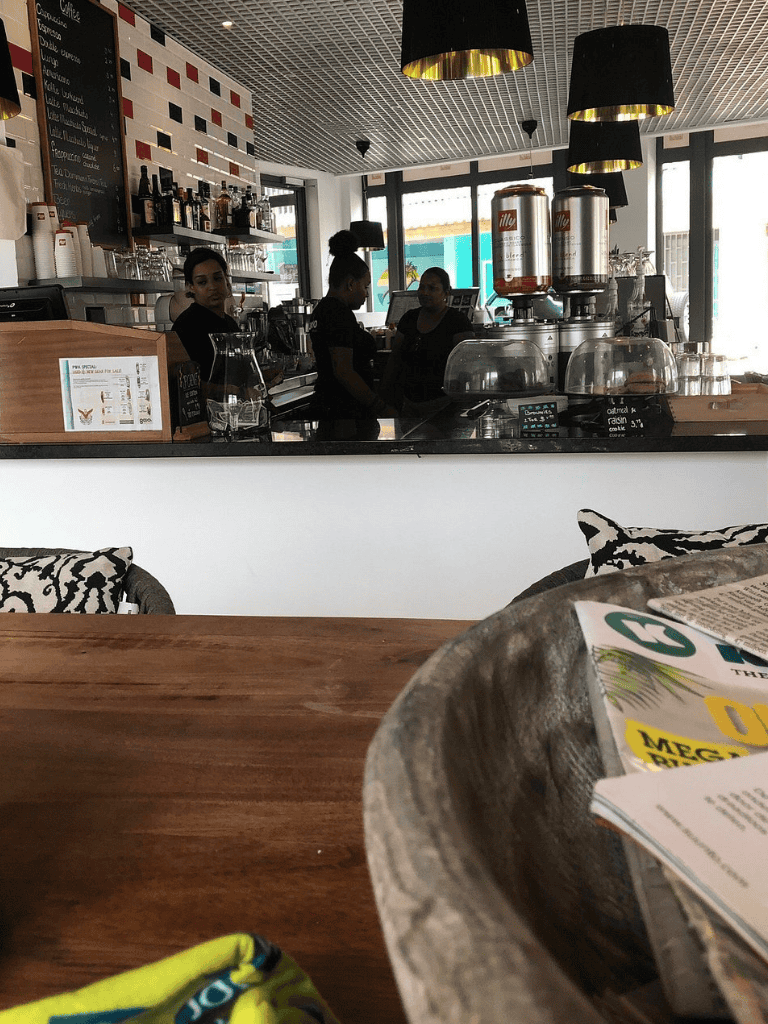 Relaxed cafe interior with baristas preparing drinks at QuestForDirections coffee shop.