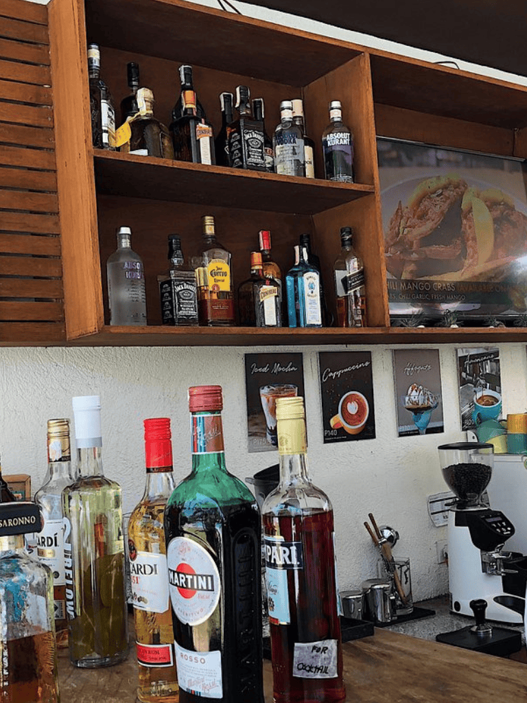 Assorted liquor bottles on bar counter with alcohol store interior in background.