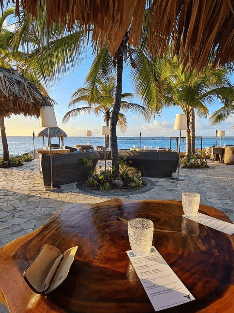 Breathtaking beachfront resort with palm trees, ocean views, and seaside dining ambiance.
