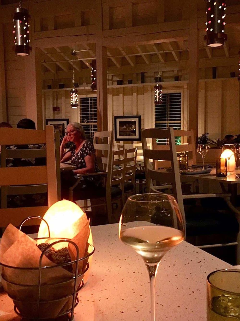 Elegant restaurant interior with cozy lighting and a woman enjoying dinner, perfect for a memorable dining experience.