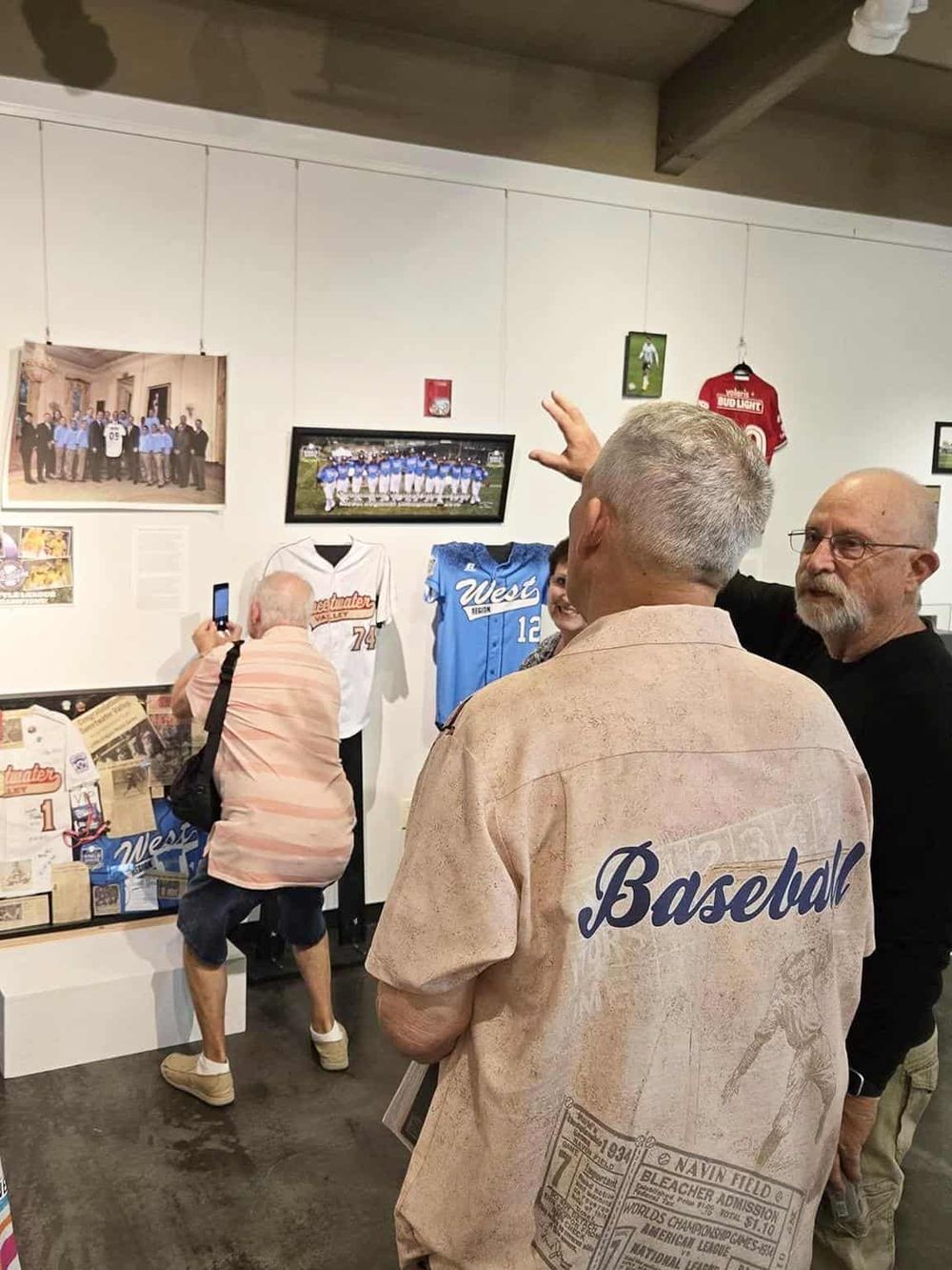 Vintage baseball memorabilia display at QuestForDirections. Fans viewing historic team photos and jerseys.