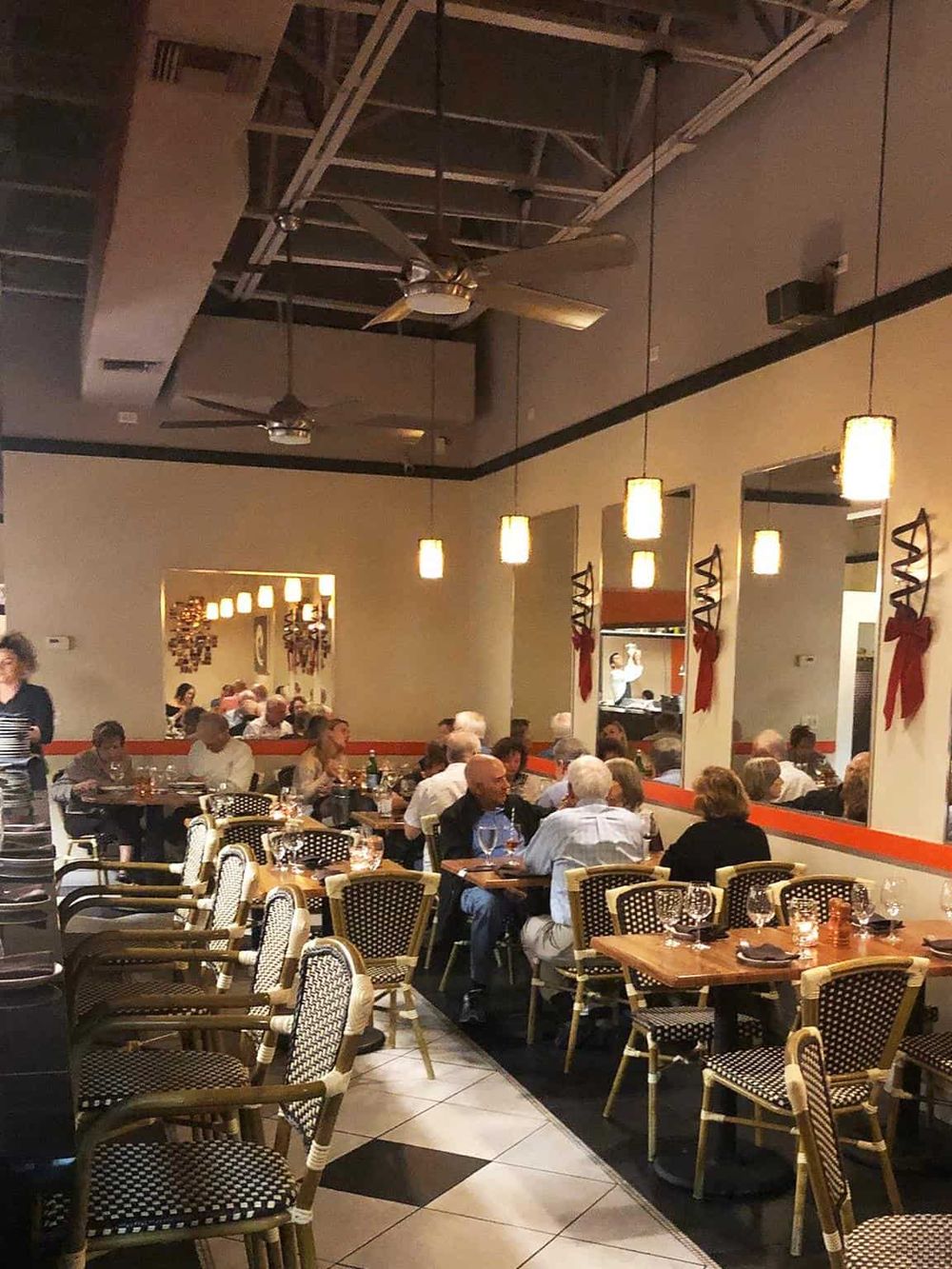 Cozy upscale restaurant with warm lighting, modern decor, and diverse guests enjoying a fine dining experience.