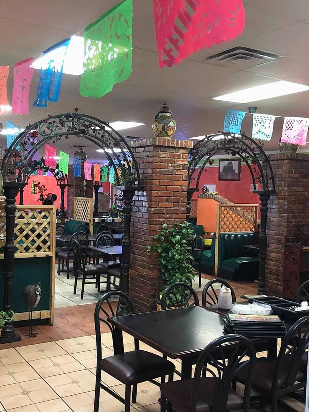 Brightly decorated Mexican restaurant with colorful papel picado banners and cozy indoor seating.