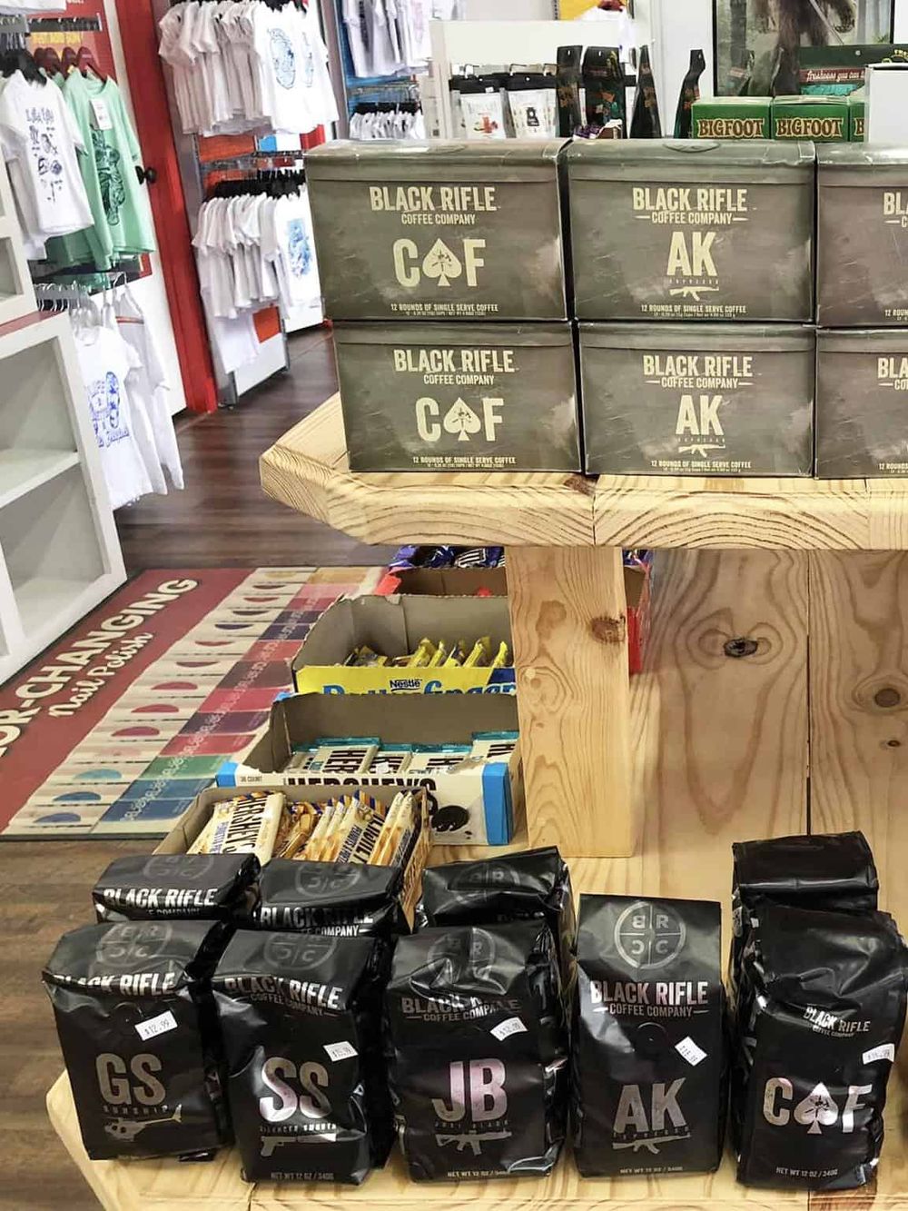 Bold Rifle Coffee Beans with various flavors displayed on wooden table in a retail store.