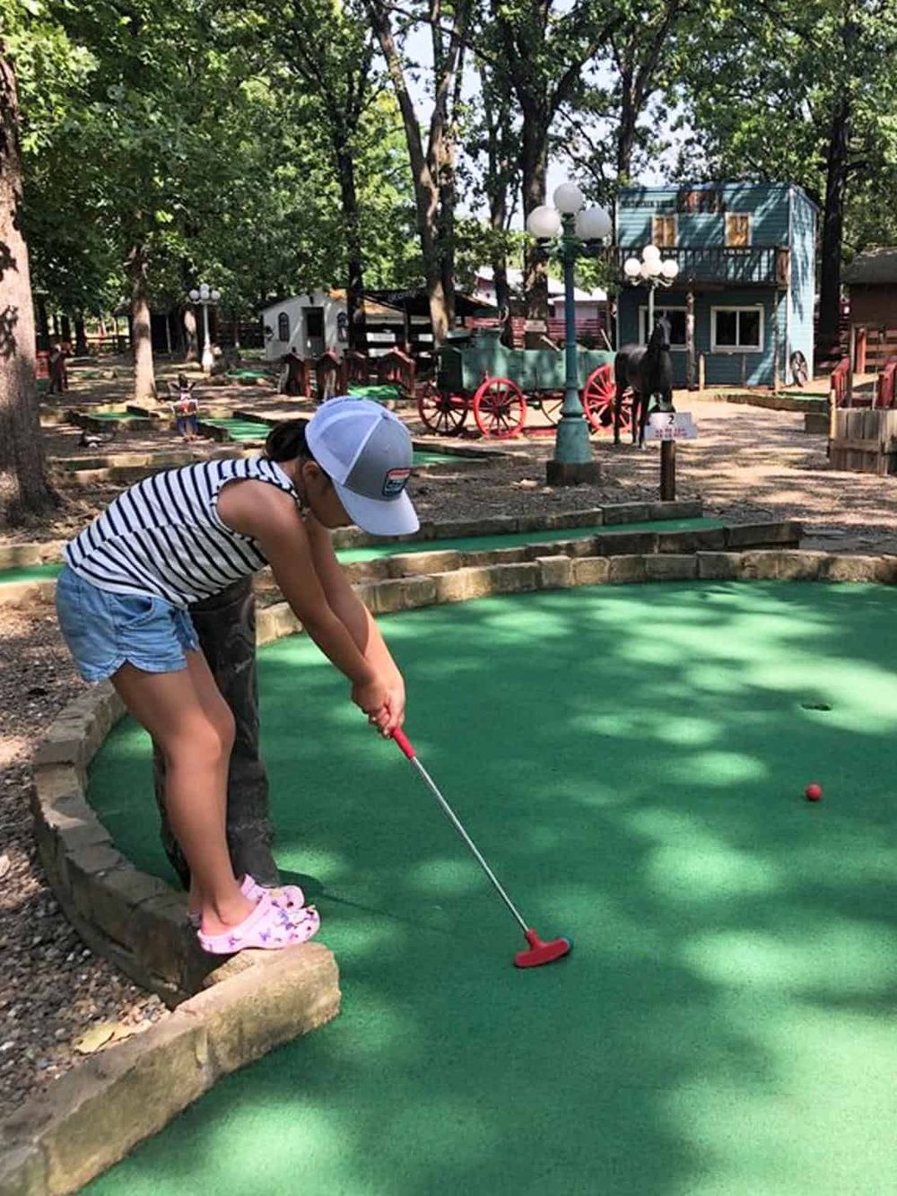 Mini golf game for kids at Quest for Directions mini golf course, family-friendly outdoor attraction.