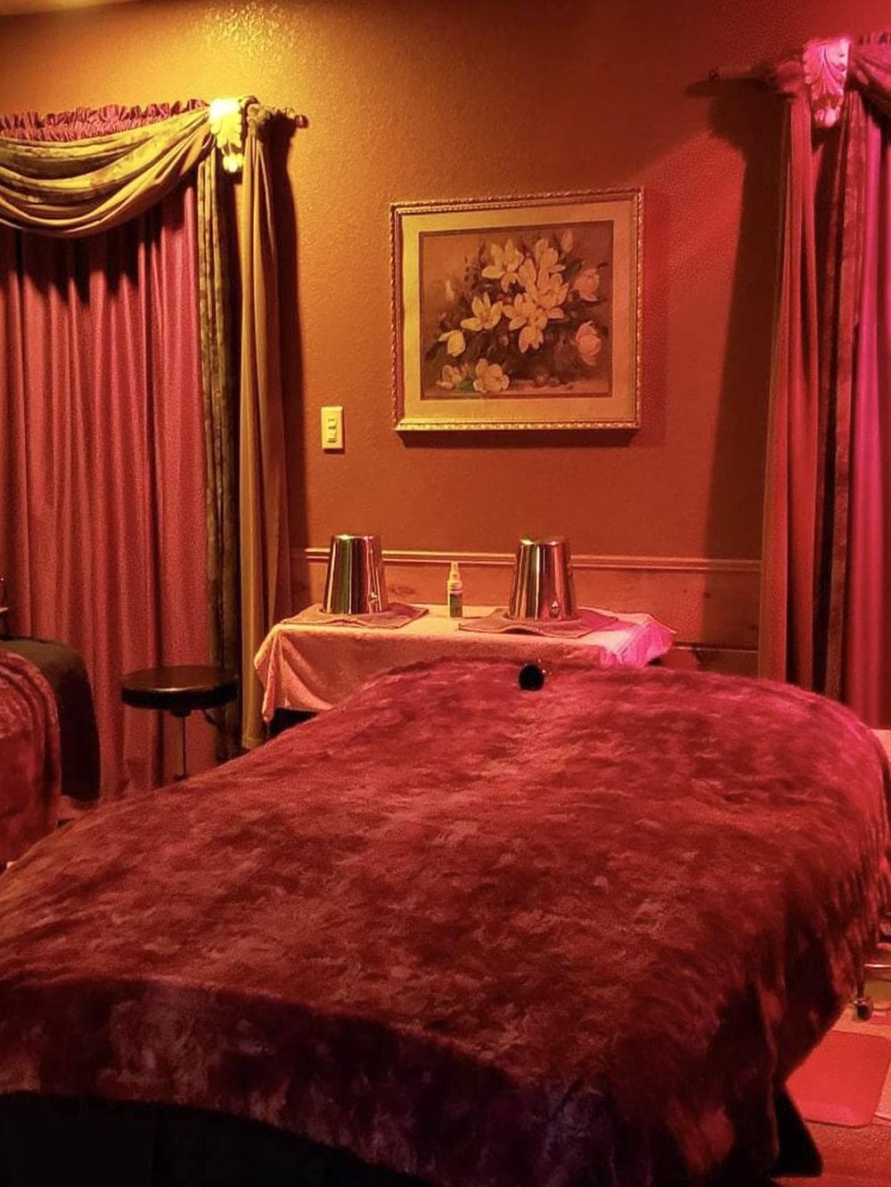 Relaxing massage room with warm red tones and cozy curtains at QuestForDirections.