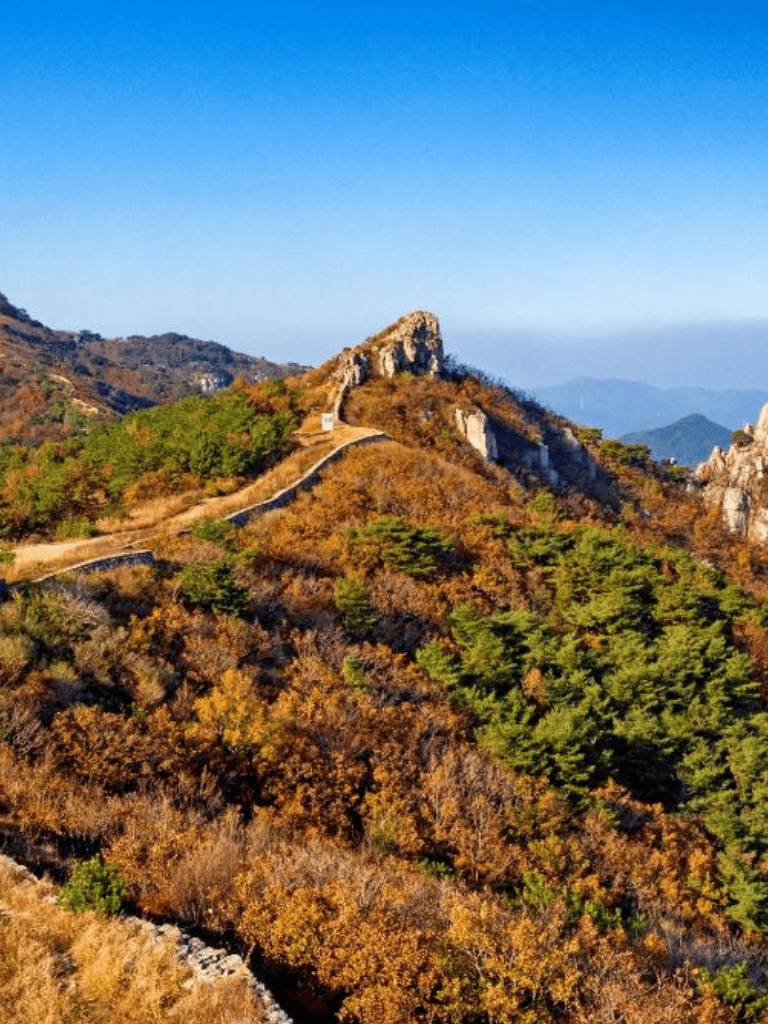 Vast mountain landscape with colorful autumn foliage and scenic trail views in the mountains.