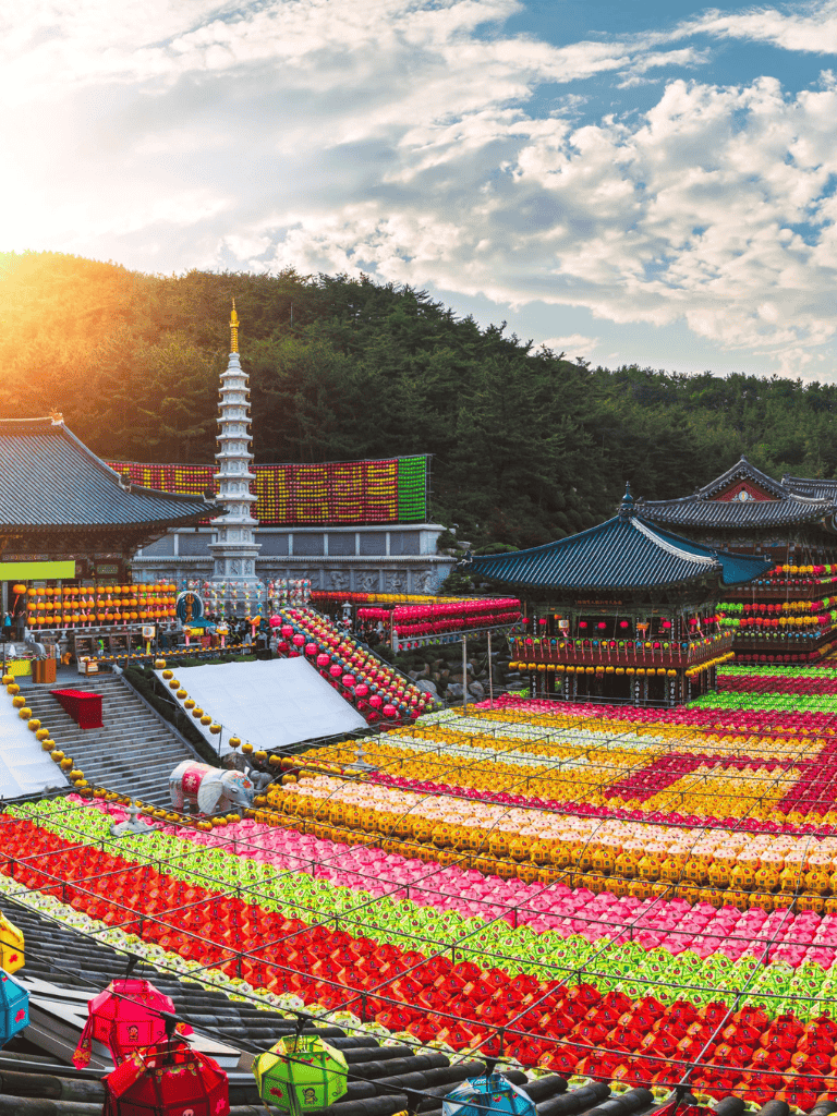 Colorful lanterns at a traditional Asian temple festival with scenic mountain backdrop.