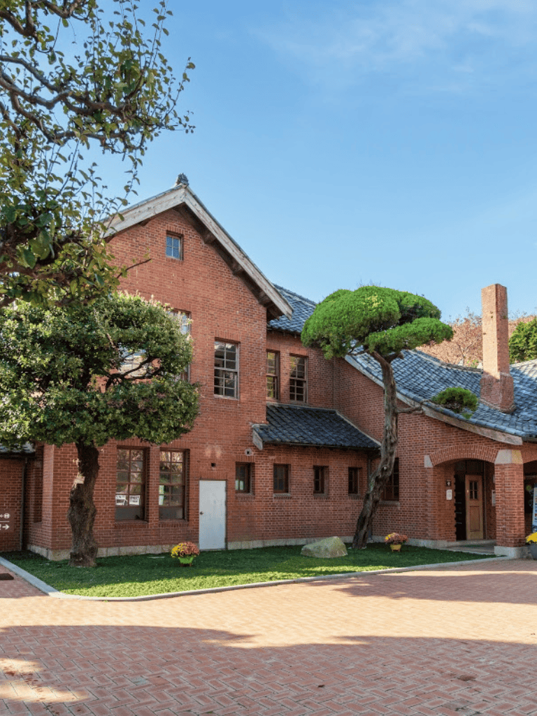 Charming historic brick house with manicured landscaping and traditional architecture.